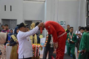 Pj Bupati Aceh Timur, Amrullah M. Ridha, mengalungkan emas untuk Tim regu Putra Provinsi Sulawesi Selatan.